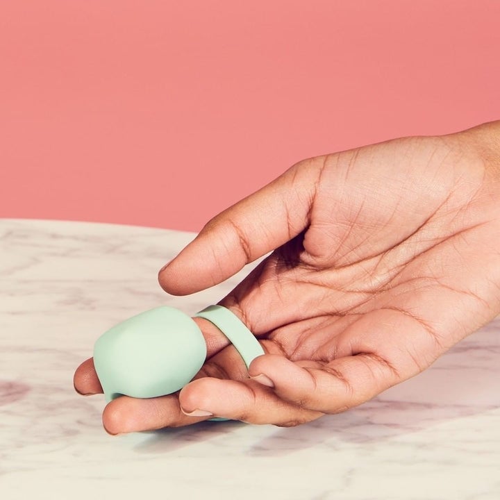 Model holding light green finger vibrator to display bulbous tip