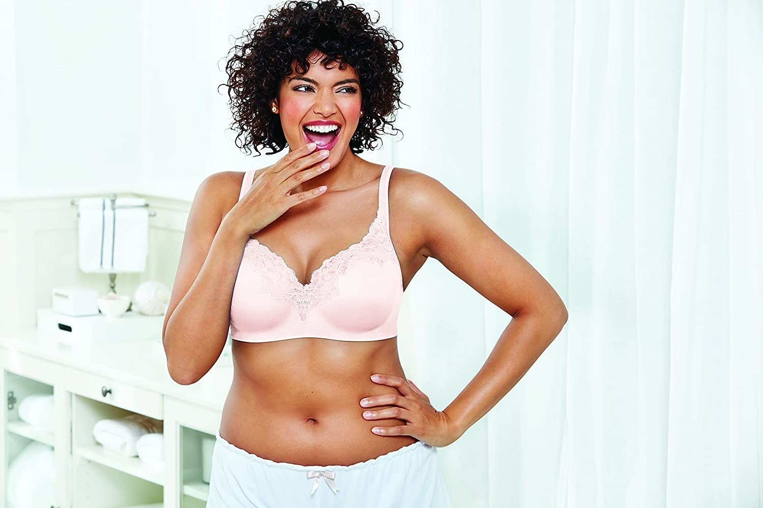 Model wearing a pink bra with lace trim around the top of the cups