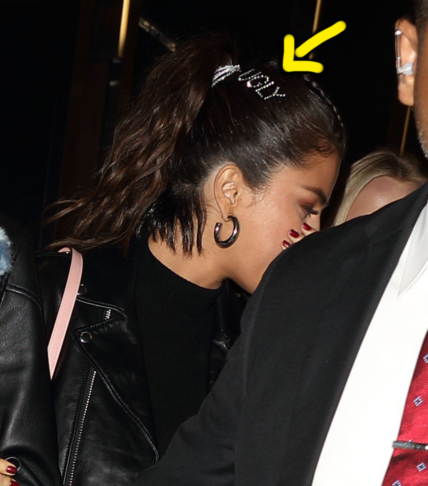 "Rare" singer wearing a sparkly clip that says "Ugly" in all caps