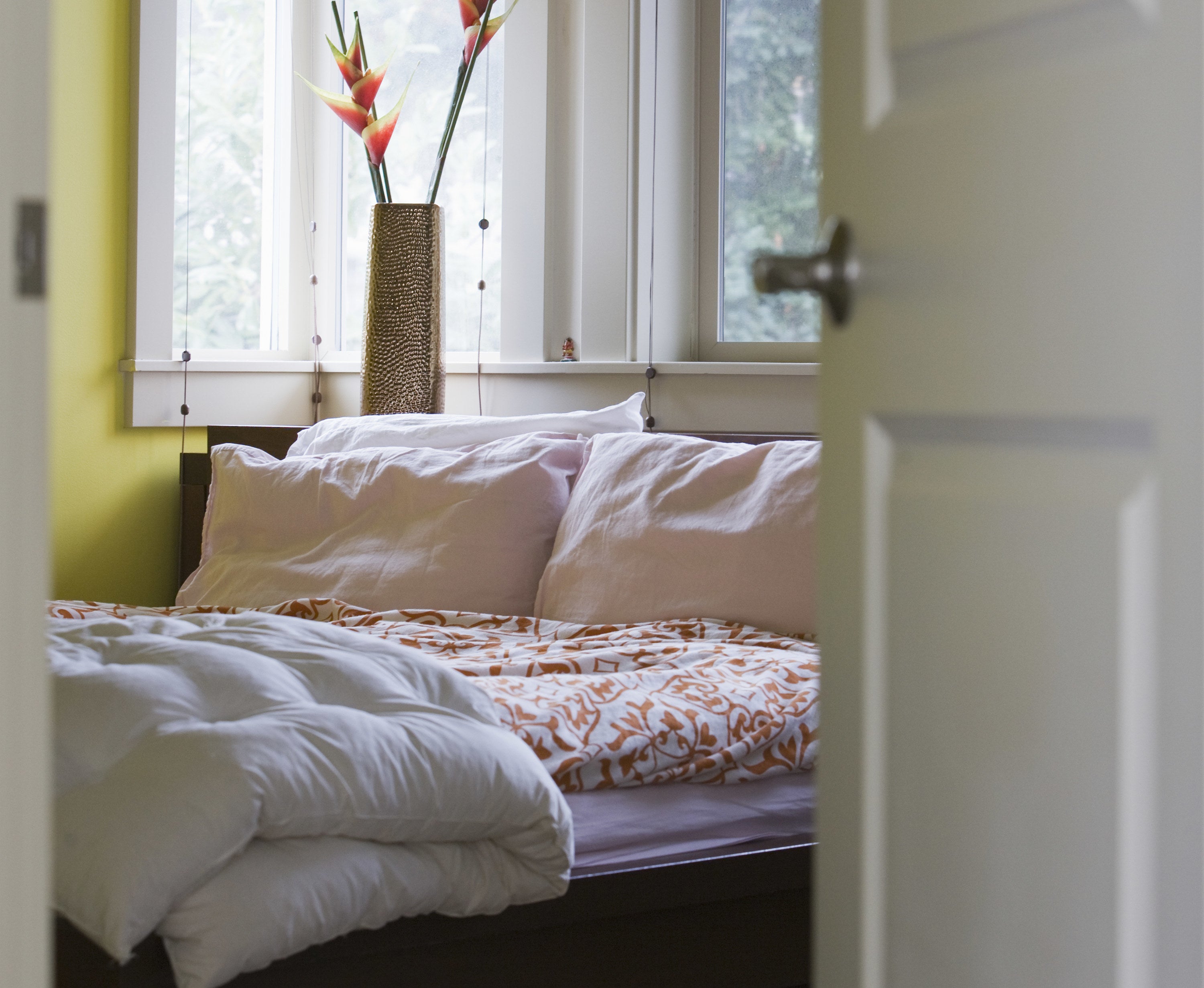 A bed seen from behind a bedroom door