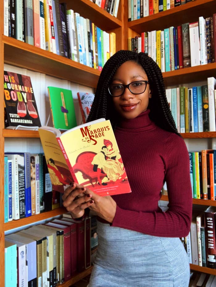 An image of the author posing with a bookshelf