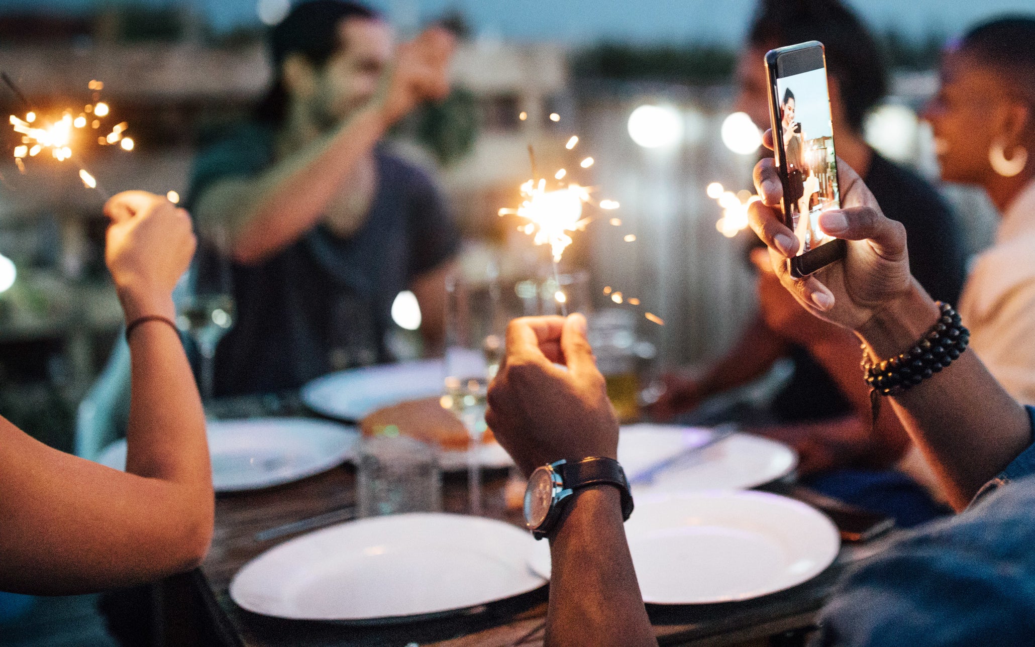 people at a table at a party with sparklers