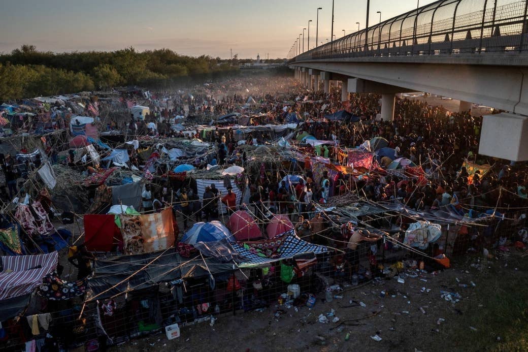 An overhead shot of a massive refugee camp under a bridge in texas
