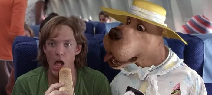 CGI Scooby sitting next to Shaggy on the plane