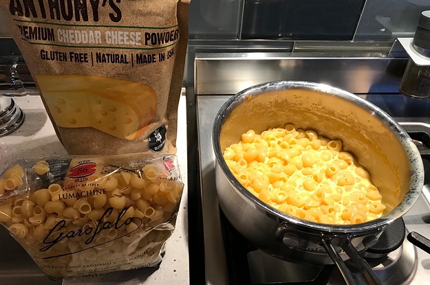 bowl of really cheesy looking mac and cheese next to the bag of powdered cheese