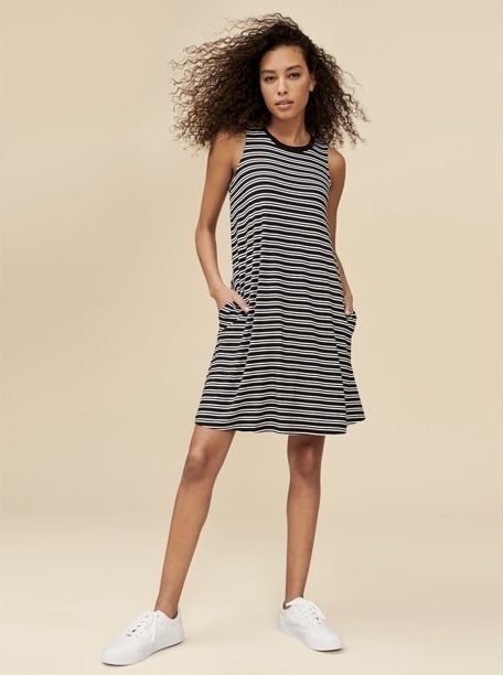 Model wearing dress in color &quot;Black and white stripe&quot; with white sneakers.
