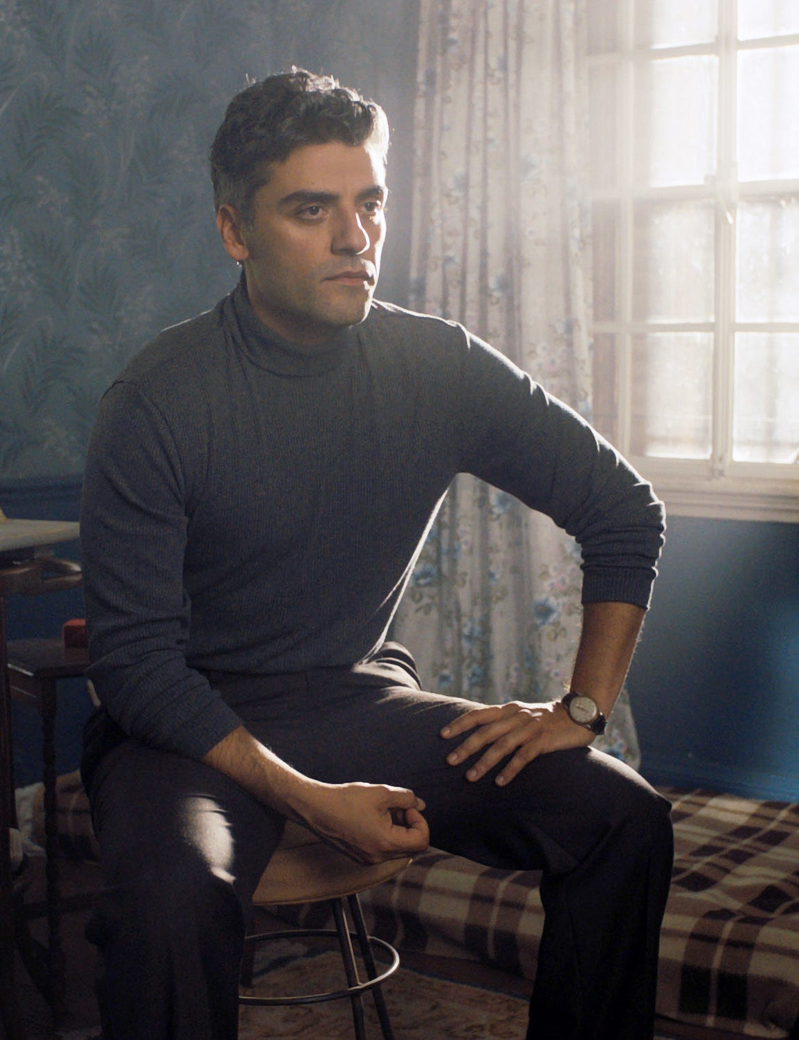 Oscar Isaac wearing a turtleneck and looking pensive