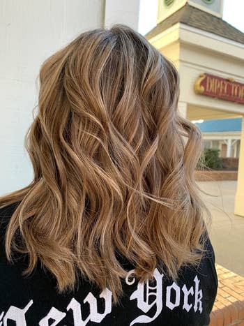 another reviewer with curled hair that looks frizz-free and shiny with the spray applied