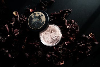 A small container of pink shimmery powder 