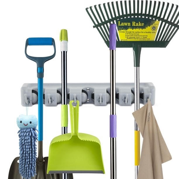 A collection of brooms and mops on a rack
