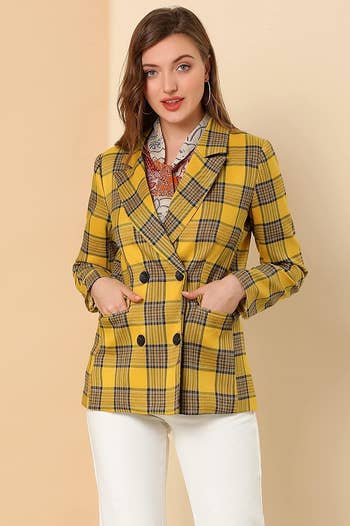 A model wearing the yellow plaid closed with their hands in the pockets
