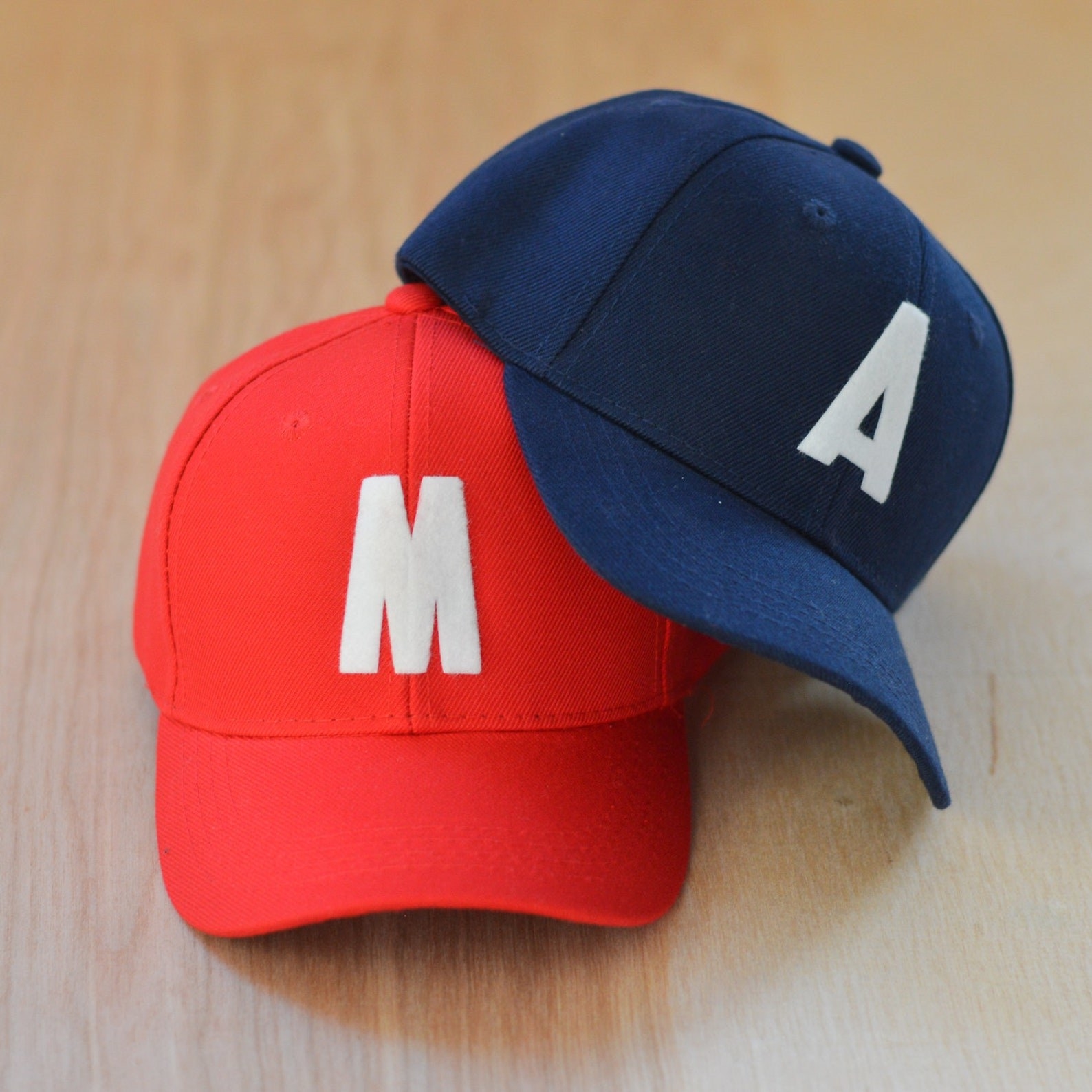 Red and navy baseball caps with single white block letters