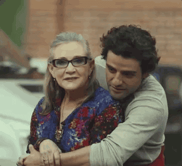 GIF of Oscar Isaac kissing Carrie Fisher on the cheek