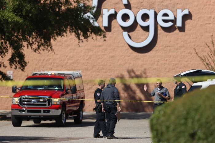 Police officers stand behind barricade tape outside a supermarket