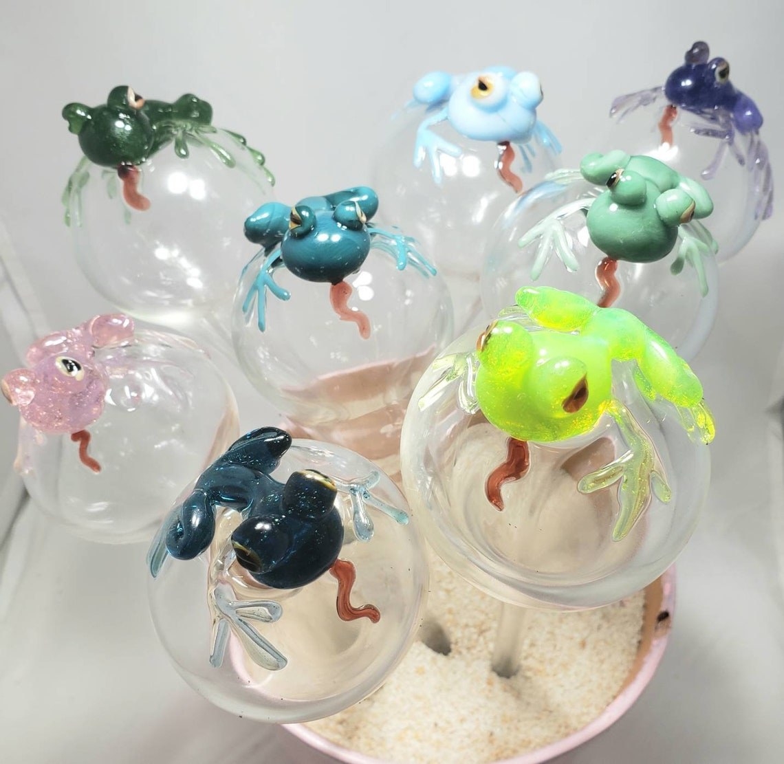 glass orbs with long stems and frogs on top