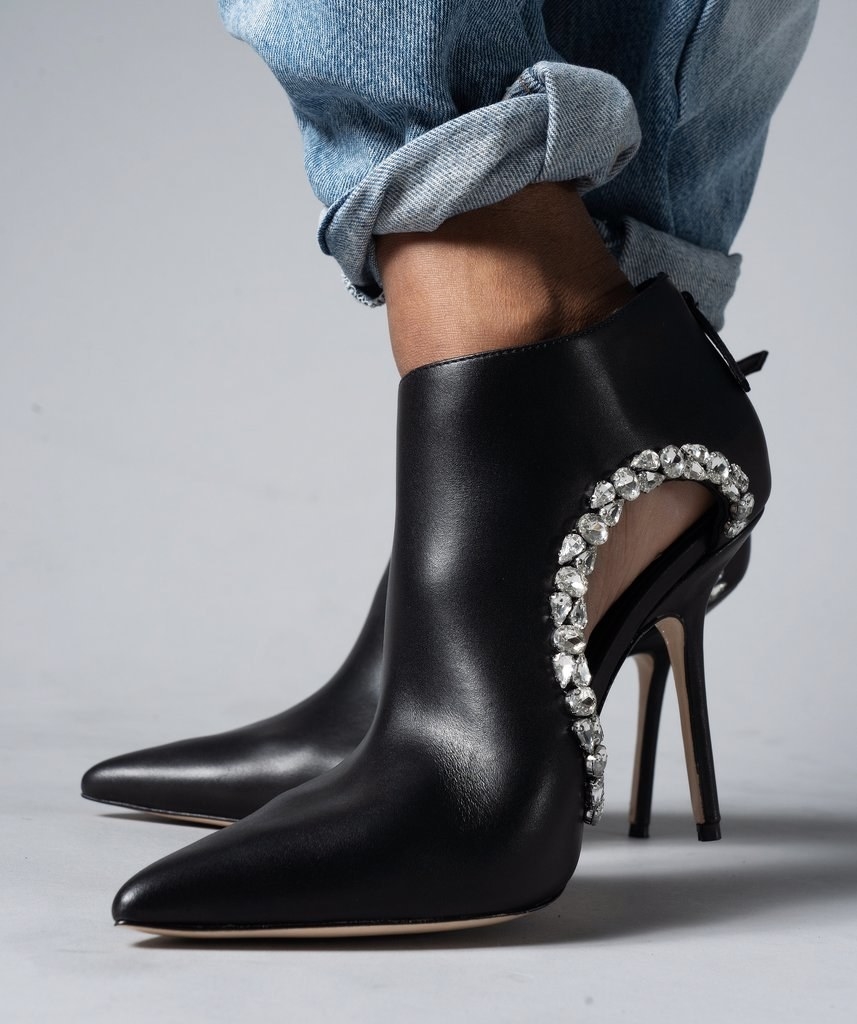 black heeled pointy toe shoes with a cut out on the side lined with stones