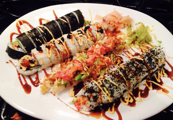 a plate of various types of sushi rolls made using the kit