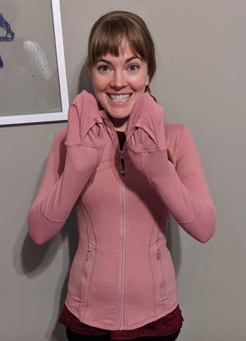 Reviewer in pink hoodie with their hands tucked into the sleeves as makeshift mittens 