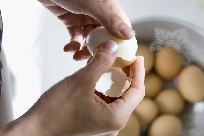 A person peeling hard-boiled eggs
