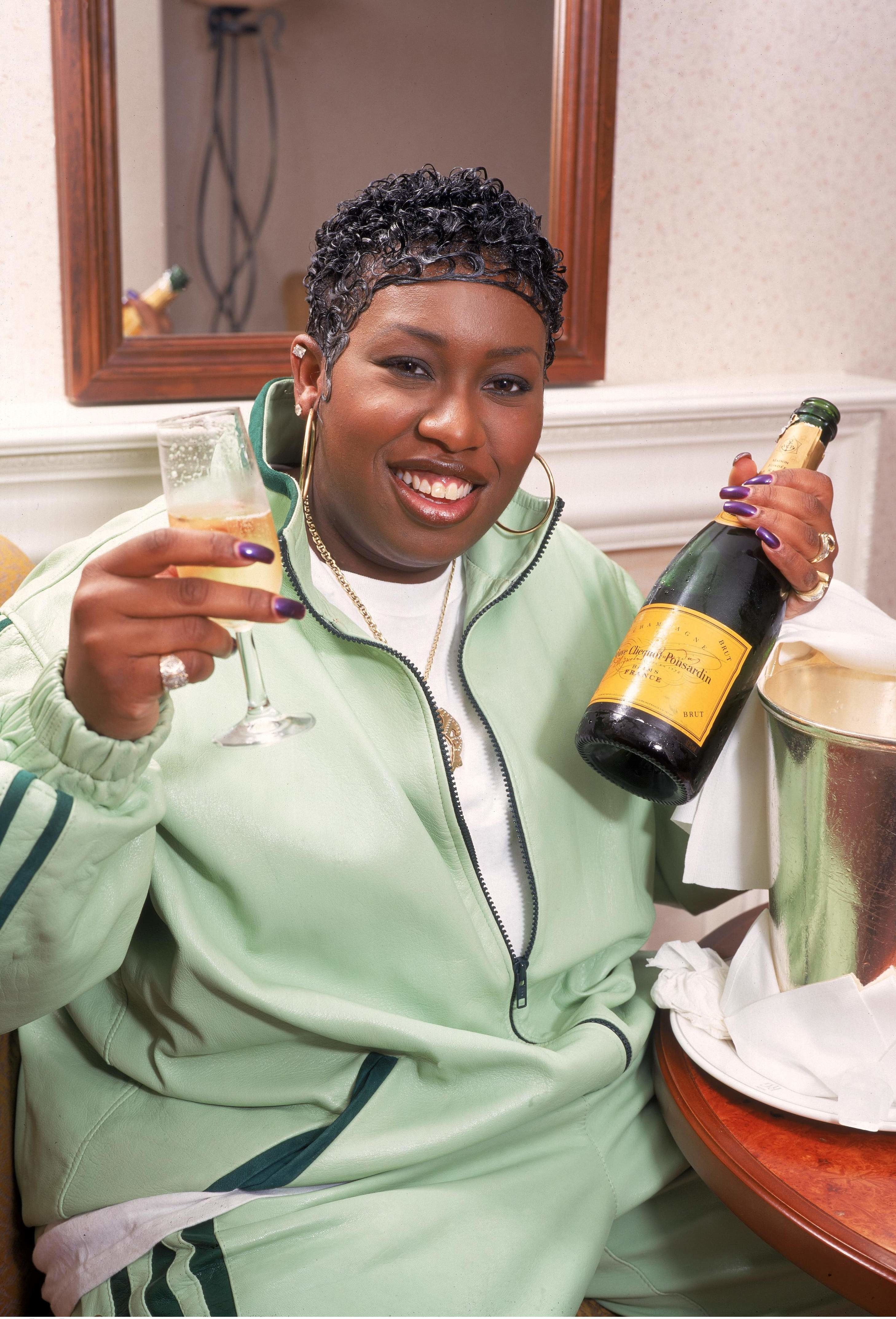Elliott posing with champagne in 1998
