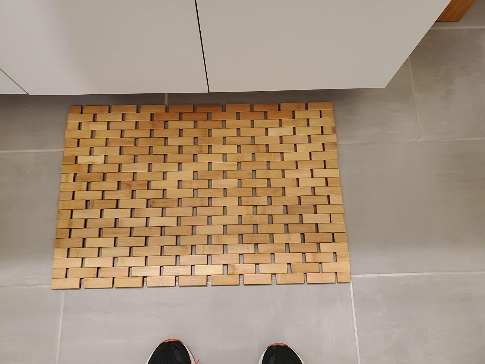 reviewer photo of bamboo bath mat on floor