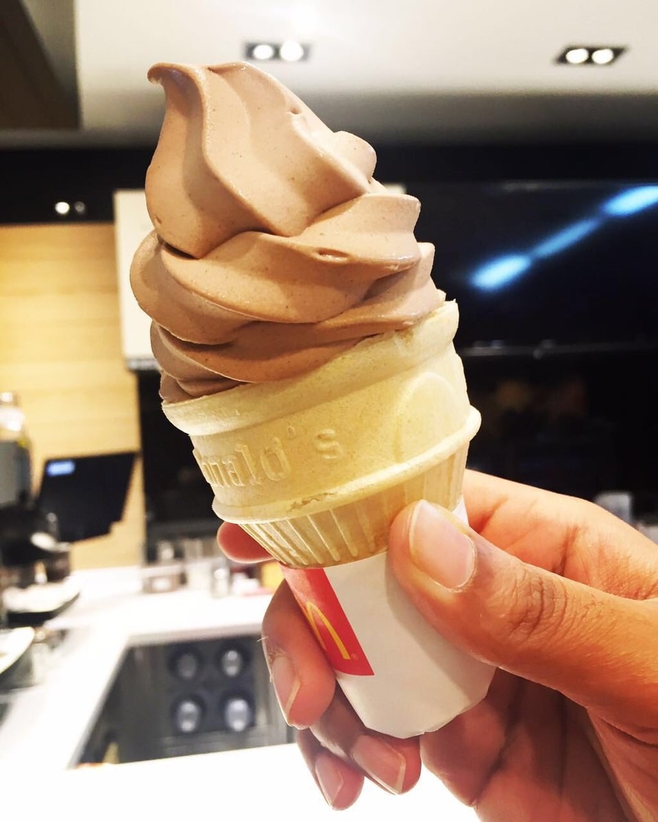 A close up of someone holding a McDonald&#x27;s chocolate soft serve