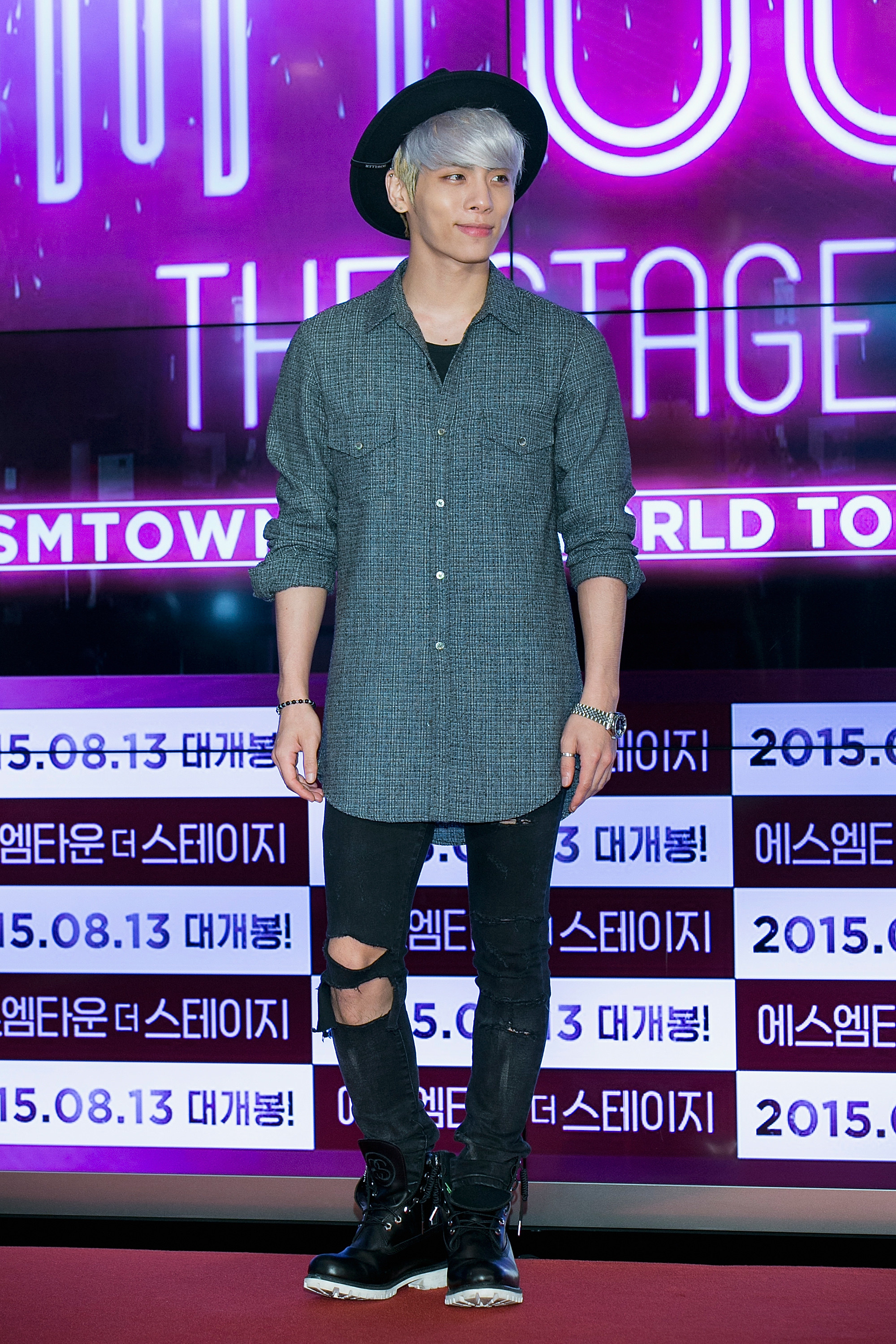 Jong-hyun Kim is casually dressed and has a closed-mouth style in front of a lit-up screen.