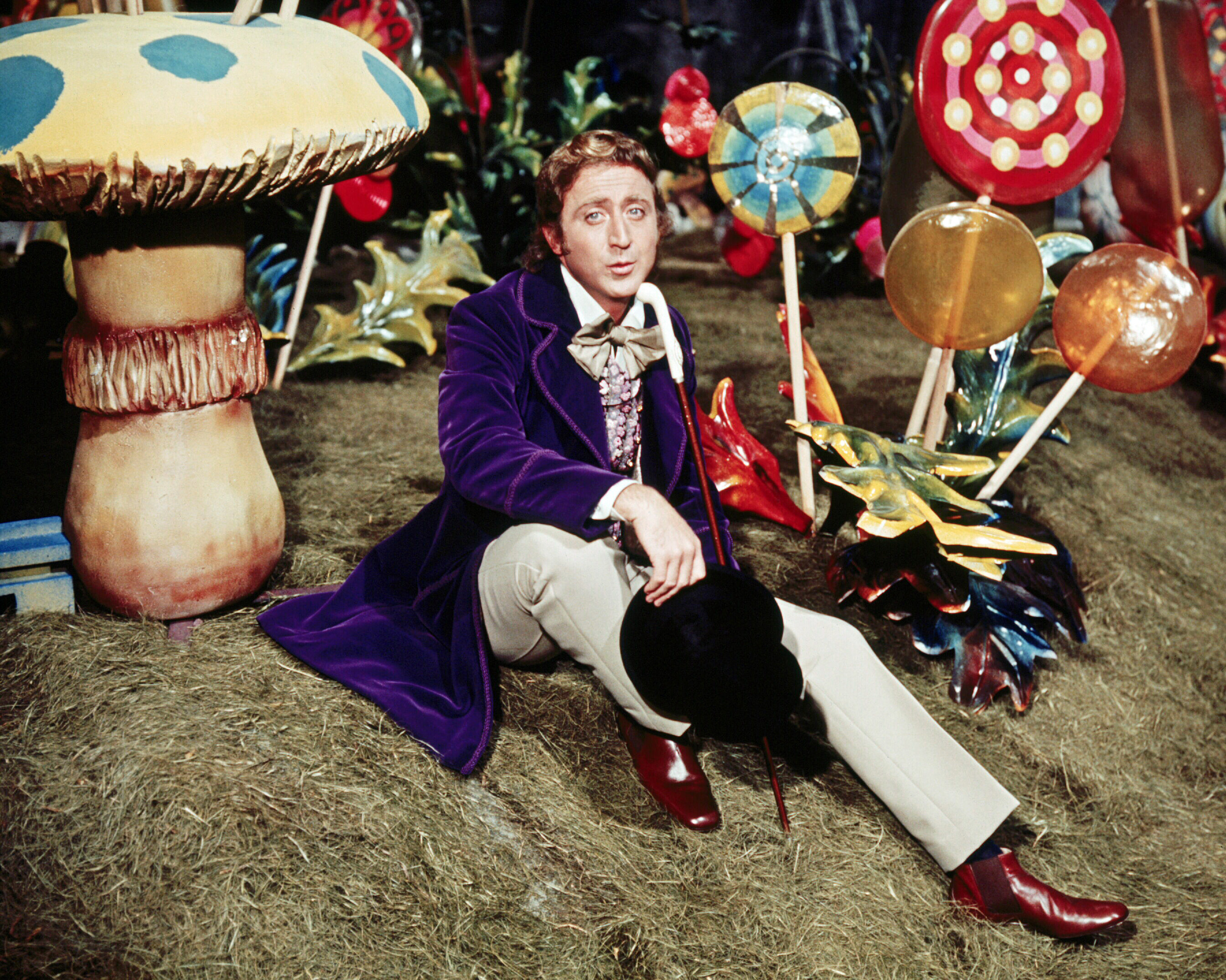 Gene Wilder sings in a scene from Willie Wonka and the Chocolate Factory, surrounded by life-size candy.