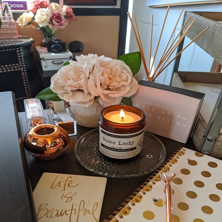 a lit candle on a reviewer's desk titled "boss lady"