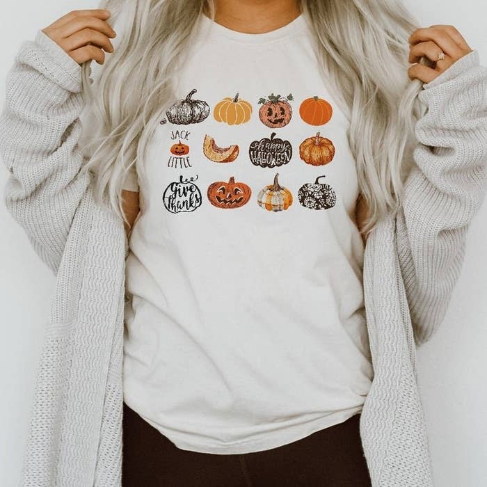 a model wearing a white tee with 12 different pumpkins on it