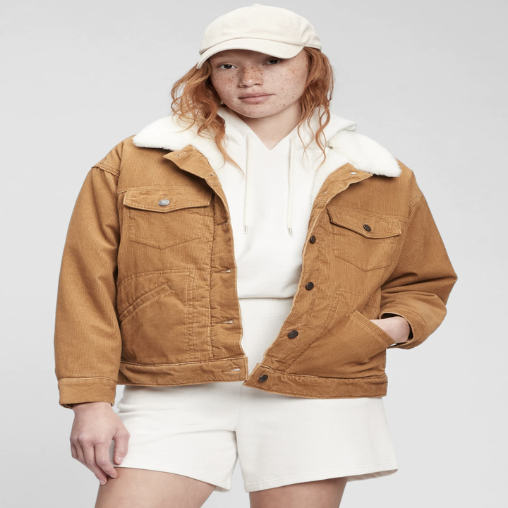 A person wearing the jacket with shorts and a hoodie