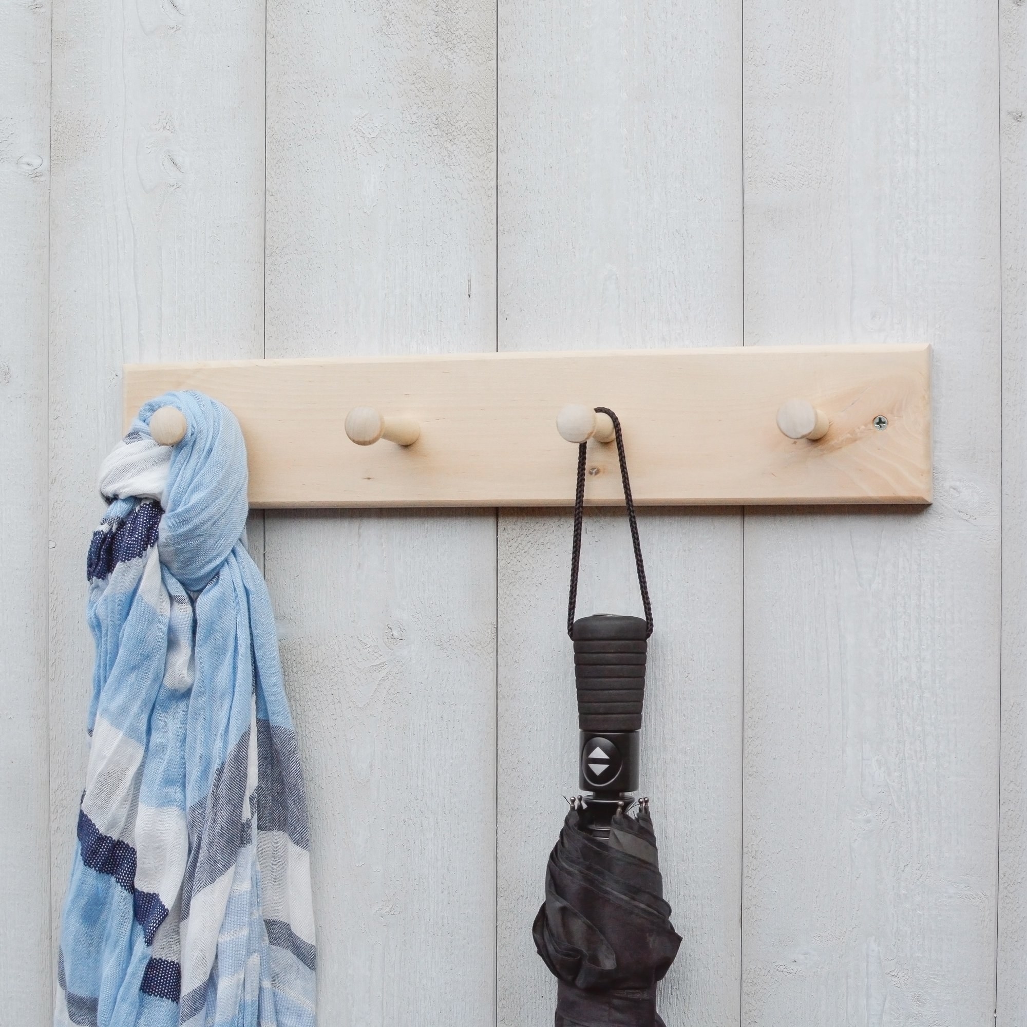 the wooden rack with a scarf and an umbrella