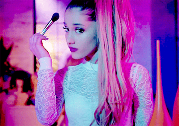 Ariana Grande using a makeup brush on her face