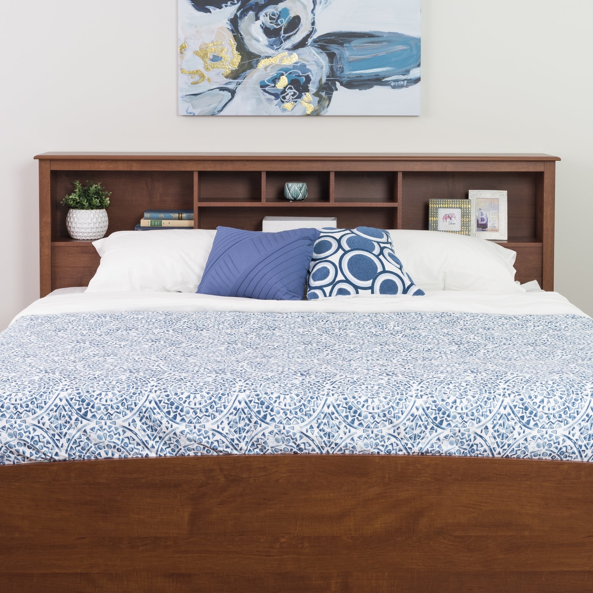 the cherry headboard with a bed made with blue linens