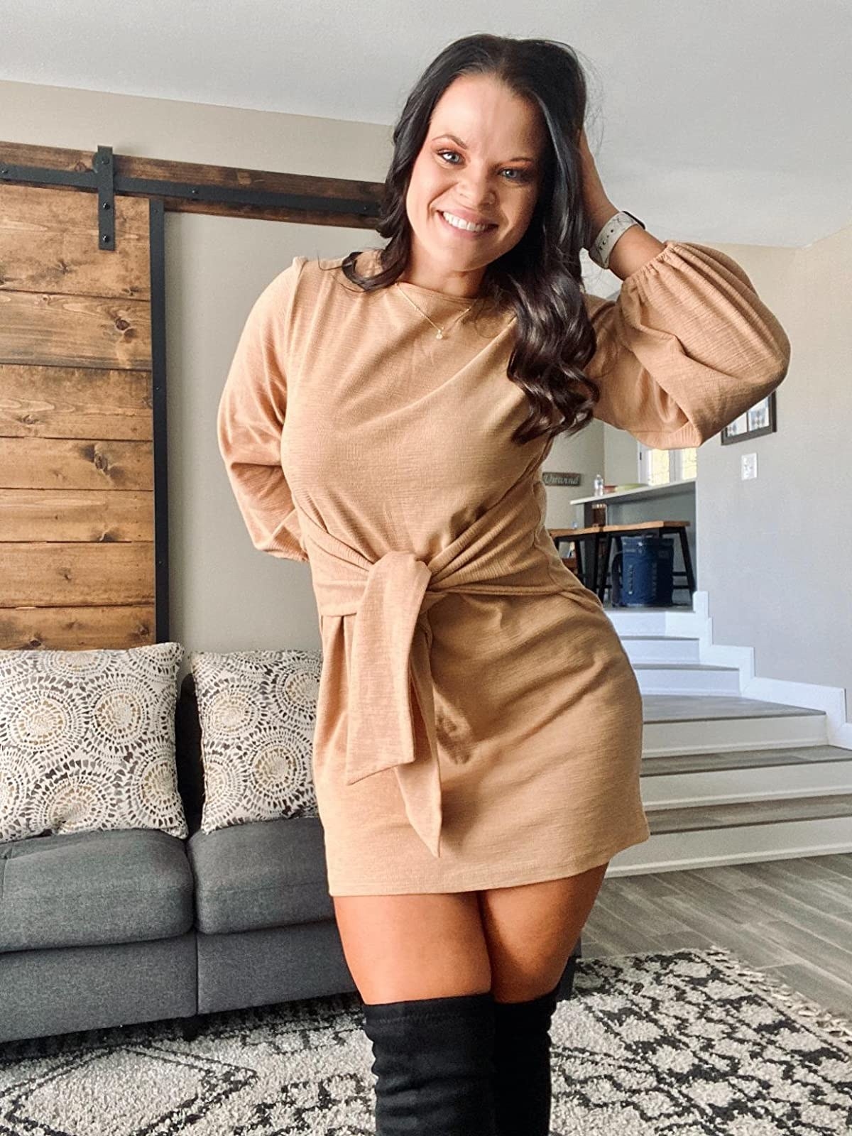 Reviewer wearing sand colored long sleeve dress, stops mid thigh