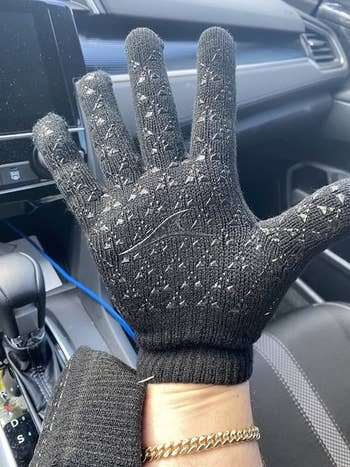 Reviewer wearing black gloves with shiny black texture /pattern