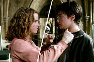 Hermione Granger and Harry Potter stand close together with the Time Turner chain hanging around both of their necks