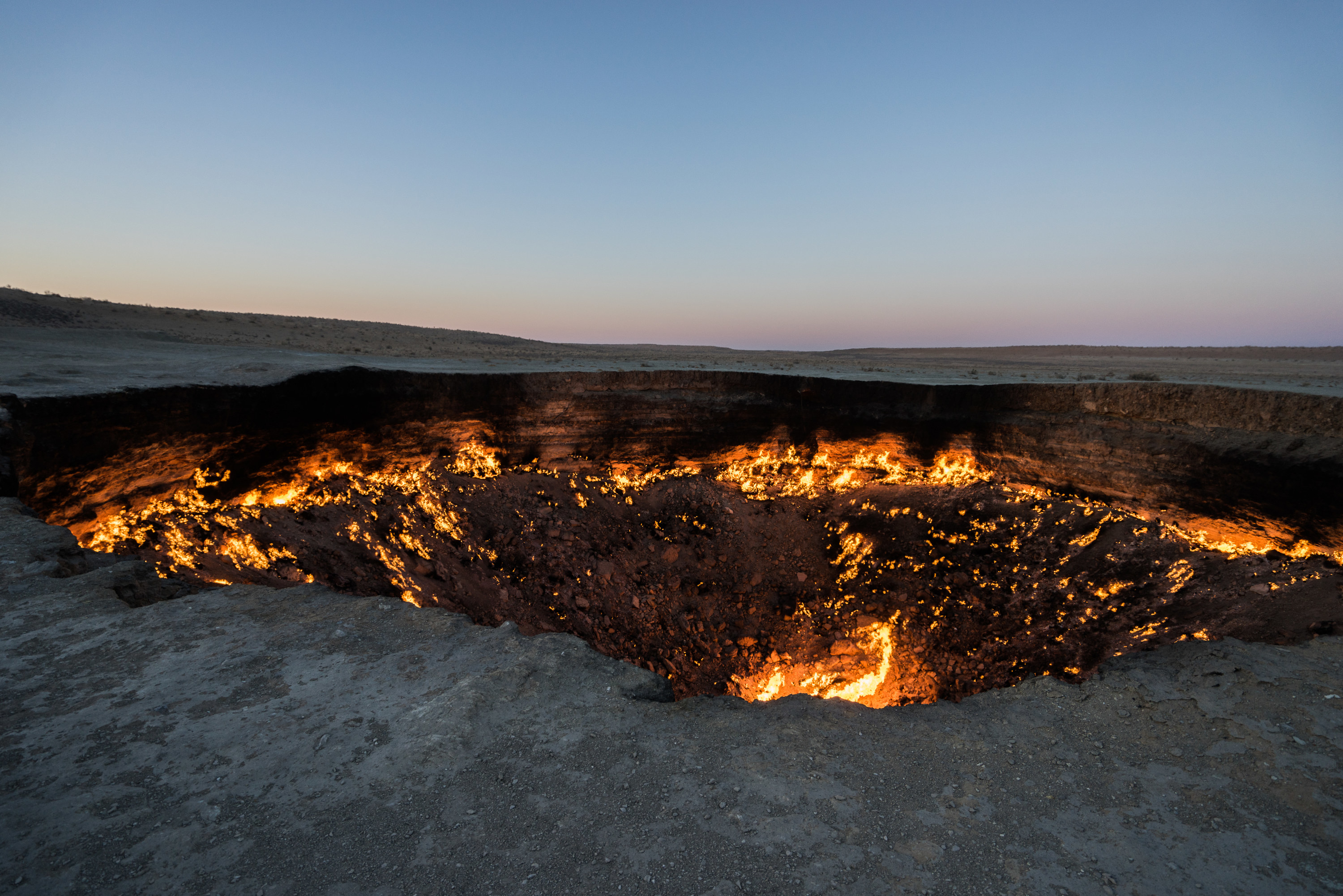 large crater in the earth filled with fire and ash