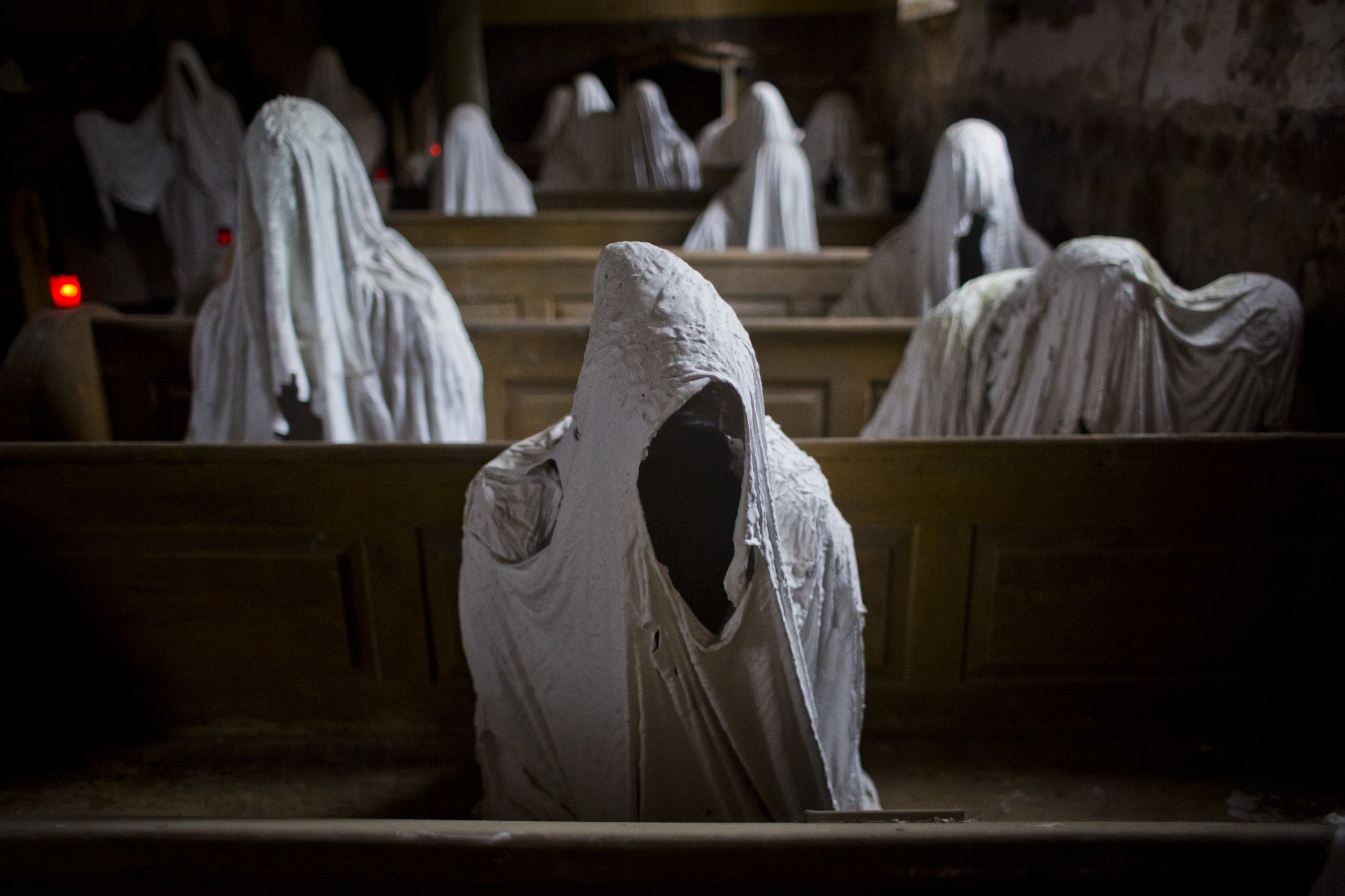 plaster ghosts sitting in pews of abandoned church
