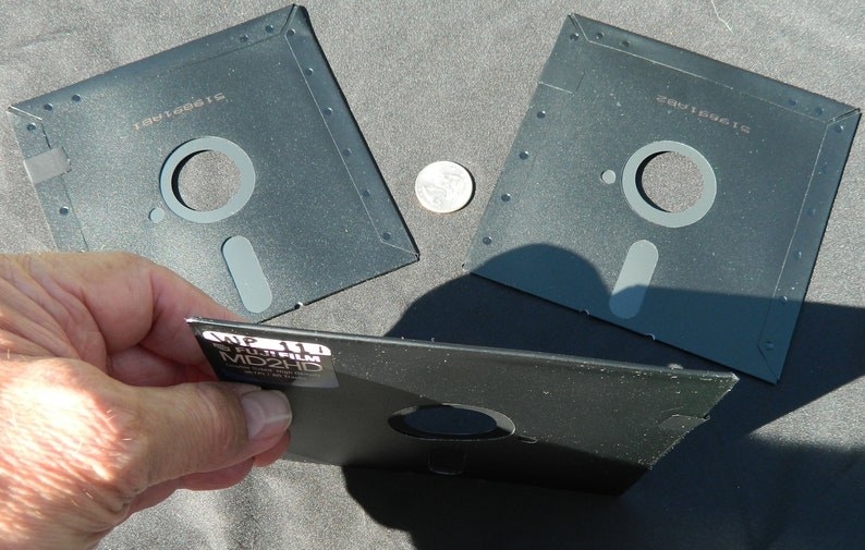 Three floppy disks with one being held up