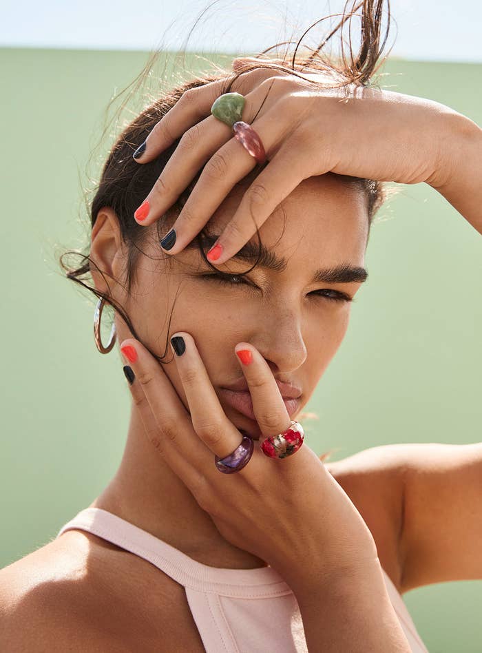 A person wearing thick rings on their fingers