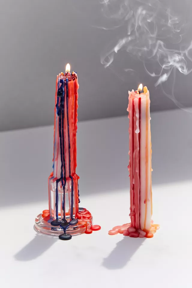 Two burn candles with wax melting onto the table