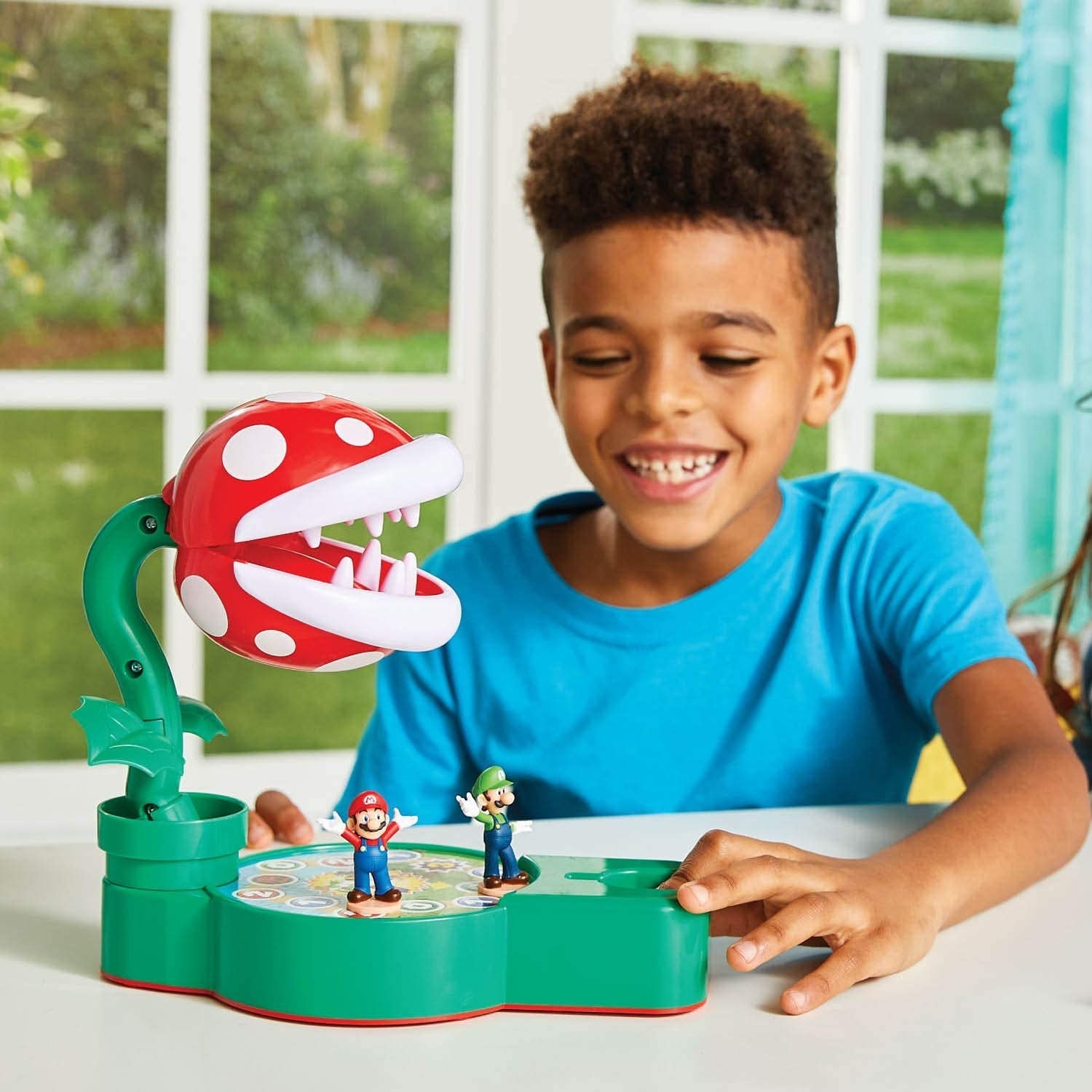 Child playing a Mario Brothers tabletop game with large piranha plant
