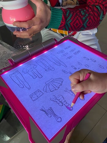 Reviewer's child drawing on the lit up pad