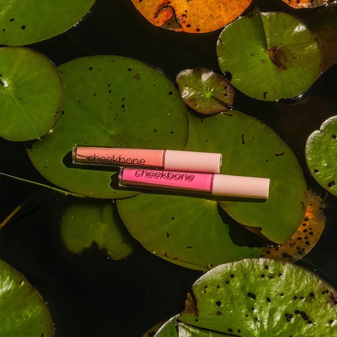 Two tubes of lip gloss on a lily pad