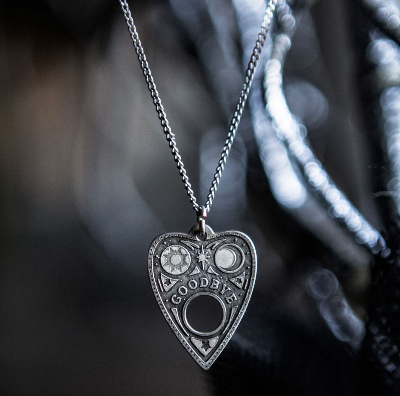 a necklace with a Ouija pendant that says &quot;Goodbye&quot;