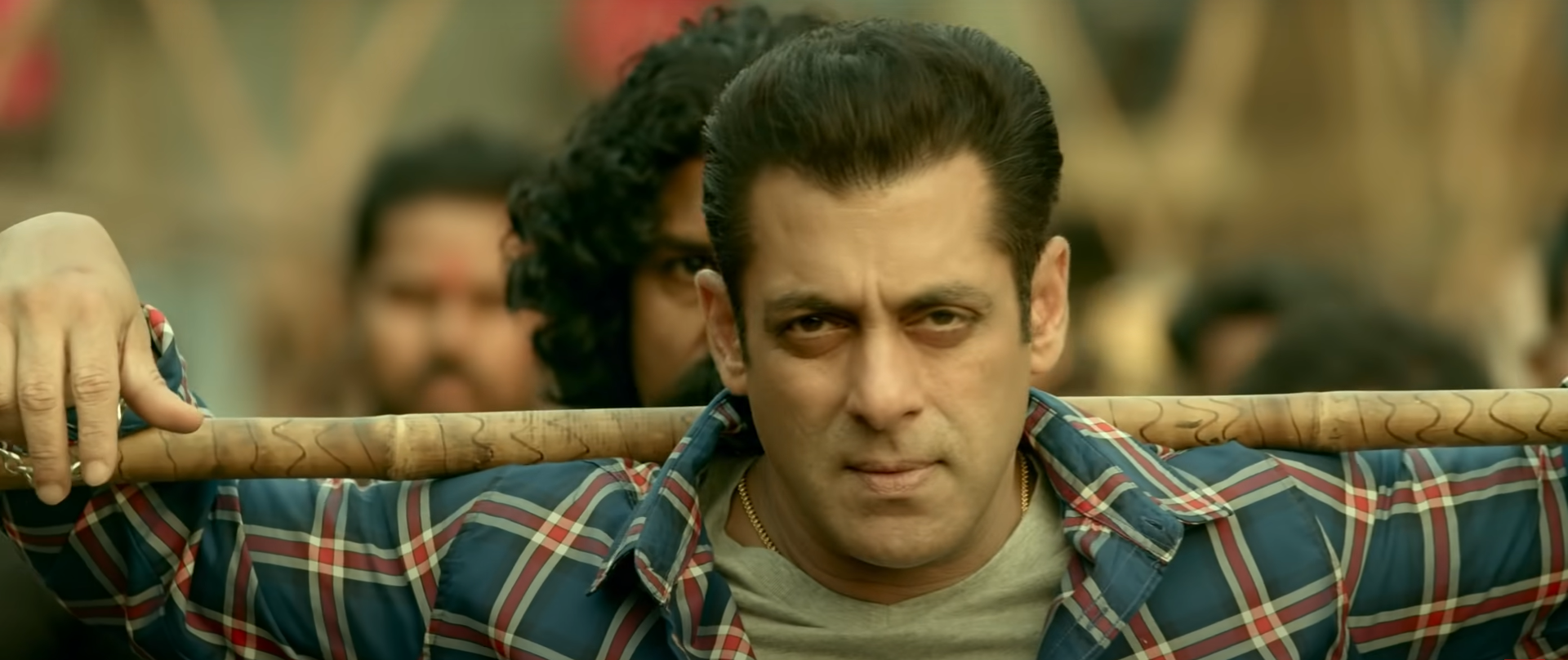 Salman Khan holding a stick over his shoulders with a determined look on his face