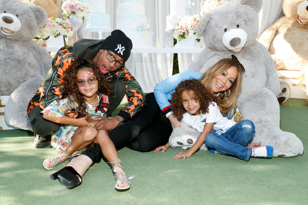 Nick and Mariah sitting on the floor with their twins, with large stuffed teddy bears behind them