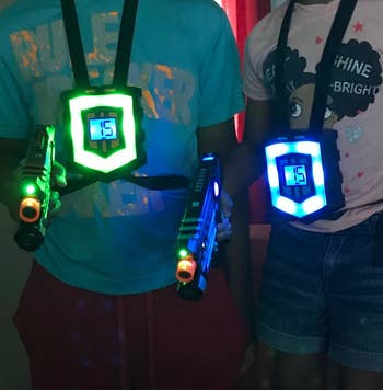 Reviewer's photograph showing 2 radical wearing the glowing vests and holding lit up laser guns