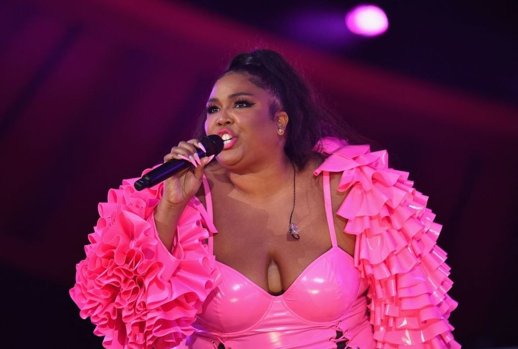 Lizzo performs onstage in a pink bodysuit